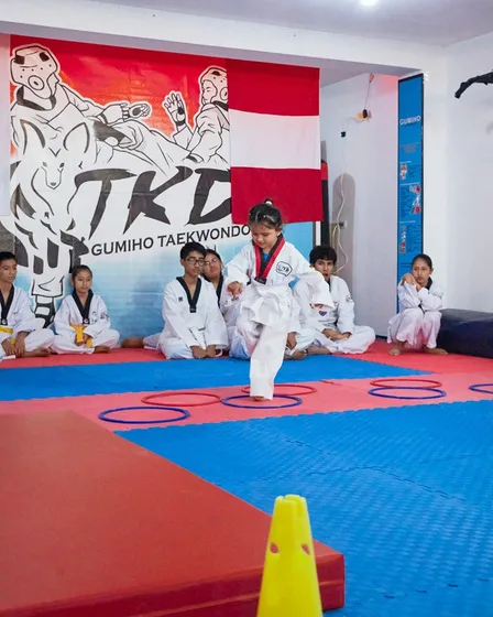 Niño pequeño pateando en clase de Pre-Taekwondo